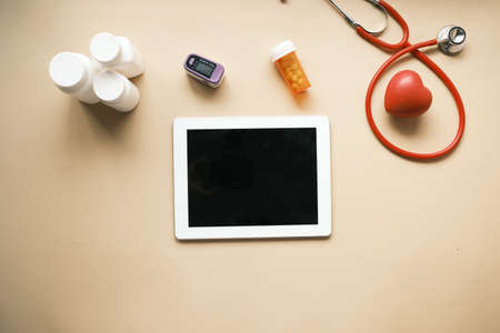 digital tablet, stethoscope and pill container on tableの写真素材