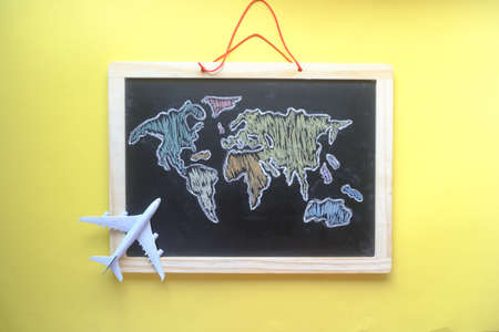 travel concept with a airplane on world map drown on chalk boardの写真素材