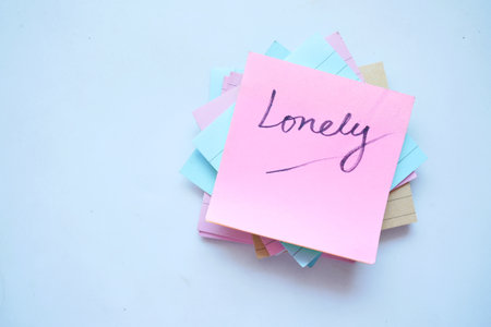 hand written lonely text on a sticky note on white backgroundの写真素材
