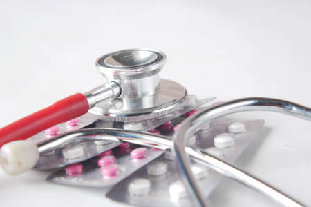 blister pack and stethoscope on blue backgroundの写真素材