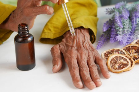 senior women applying essential oils on handの写真素材