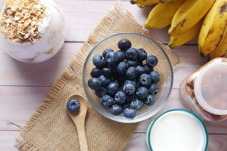 fresh blue berry in bowl with banana, milk and almond on tableの写真素材