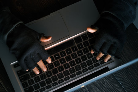hacker hand stealing data from laptop top downの写真素材