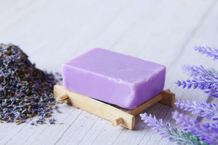 Homemade natural soap bar and lavender flower on purple backgroundの写真素材