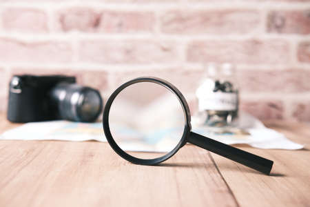 magnifying glass, camera and map on tableの写真素材
