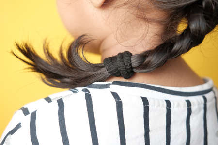 child girl with long hair against yellow background ,の写真素材