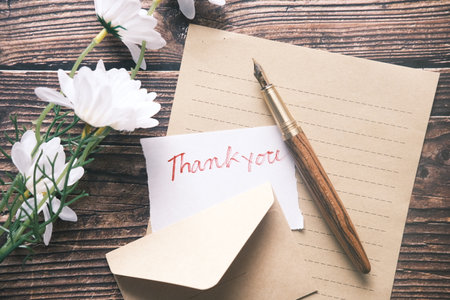 thank you message and envelope on wooden tableの写真素材