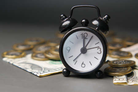 alarm clock , coins and cash on dark backgroundの写真素材