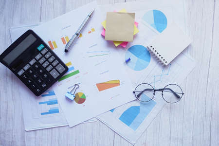 top view of financial graph, calculator and notepad on tableの写真素材