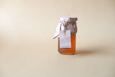 fresh honey in a glass jar with a paper empty labelの写真素材