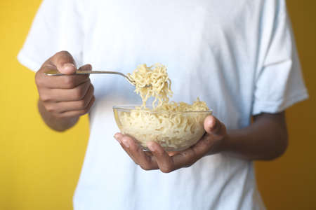 boy eating noodles in a bowlの写真素材