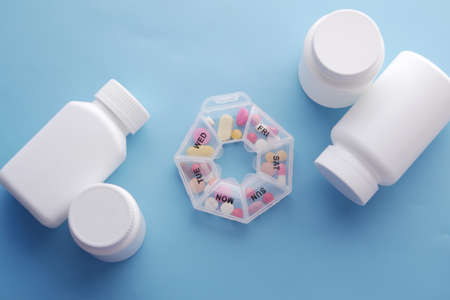 top view of medical pills and pill box on blueの写真素材