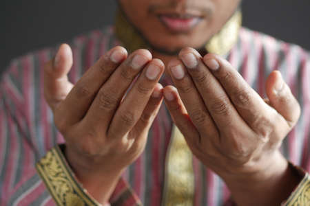 muslim man keep hand in praying gestures during ramadan, Close upの写真素材