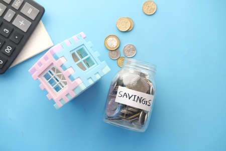 house finance concept with house model and saving coin jar on tableの写真素材
