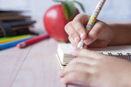 child hand writing on notepadの写真素材