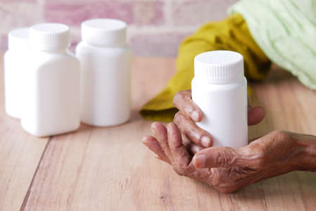 senior women hand holding medicine pill containerの写真素材