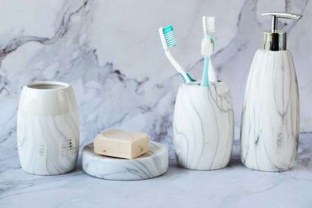 toothbrushes in white mug and soap on tiles backgroundの写真素材