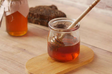 close up of fresh honey with spoon on tableの写真素材