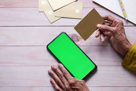 senior women hand holding credit card and using smart phone shopping online