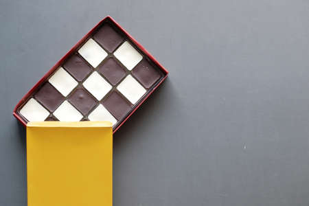 dark and white chocolate in a box on gray backgroundの写真素材