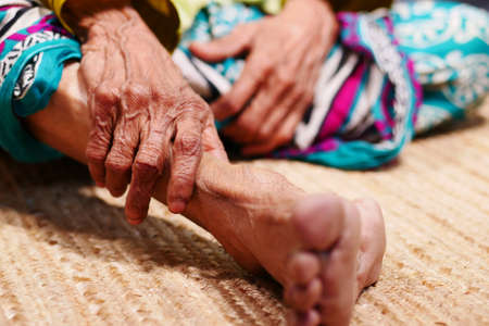 Close up on senior women feet and hand massage on injury spot.の写真素材