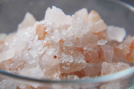 close up of pink rock salt in a bowl on tableの写真素材