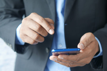 Close up of young man hand using smart phone.
