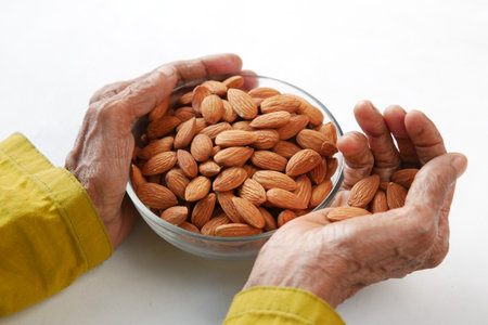 close up senior women hand holding a bowl on almondの写真素材