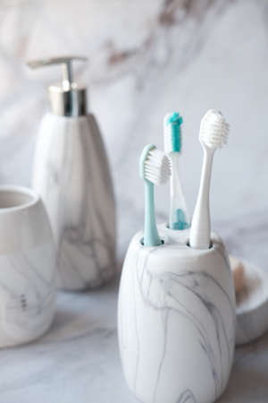 colorful toothbrushes in white mug against a wallの写真素材
