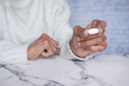 senior women holding a medical pills while sited