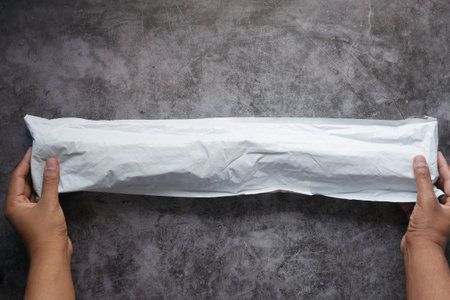 holding a delivery envelope on black backgroundの写真素材