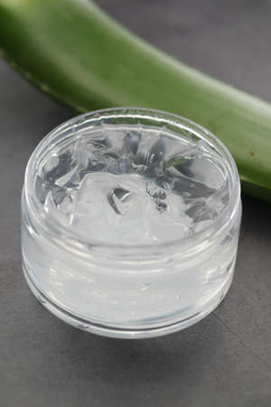 Fresh aloe vera sliced and liquid gel in plastic container on white backgroundの写真素材