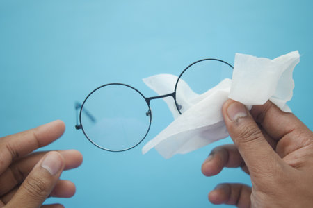 cleaning eyeglass with tissue close upの写真素材