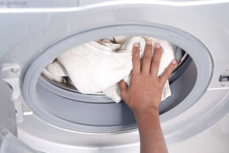 putting towel and cloths in a washing machine.の写真素材