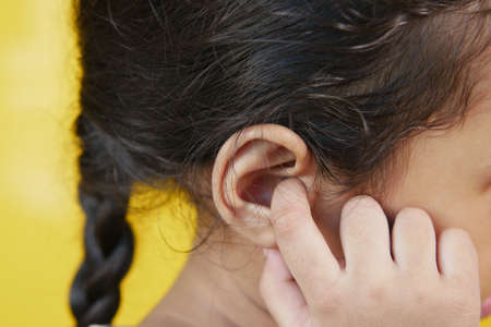 child girl having ear pain touching his painful ear ,の写真素材