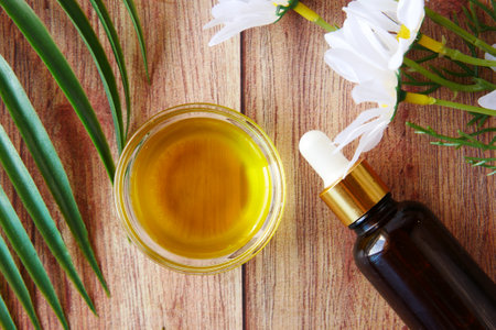 eucalyptus essential oils in a glass bottle and flower on tableの写真素材