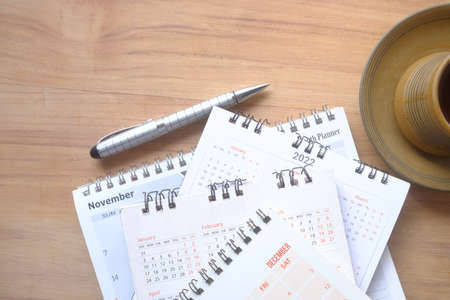 tack of calendar and cup of tea on tableの写真素材