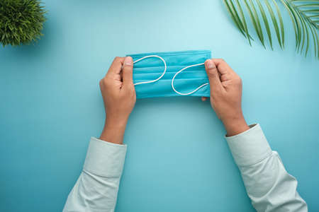 man hand holding surgical face mask, close upの写真素材