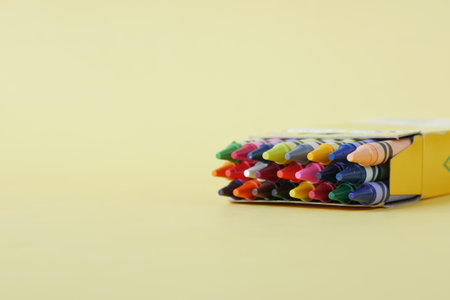 Color pencils on yellow papers on tableの写真素材