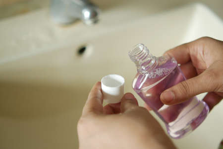 women hand hold a mouthwash liquid containerの写真素材