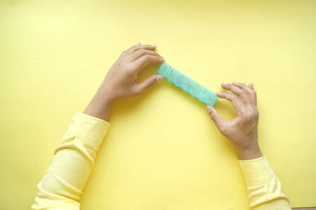 mans hands taking medicine from a pill box on yellow backgroundの写真素材