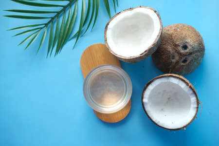 top view of slice of fresh coconut and bottle of oil on a tableの写真素材