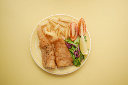 Fish fillet, lemon , chips and potato mash on table