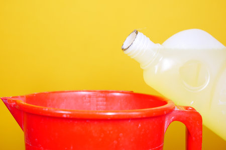 floor cleaning disinfect bottle against yellow backgroundの写真素材