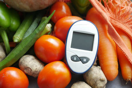 diabetic measurement tools and fresh vegetable on tableの写真素材