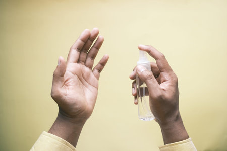close up of young man hand using hand sanitizer spray.