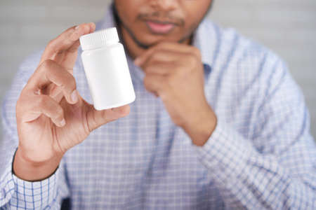 young man hand holding medicine pill containerの写真素材