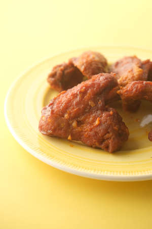chicken wings in a plate on yellow backgroundの写真素材
