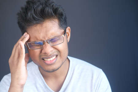 Young man suffering headache, close upの写真素材