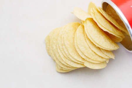tasty potato chips spilling from a containerの写真素材